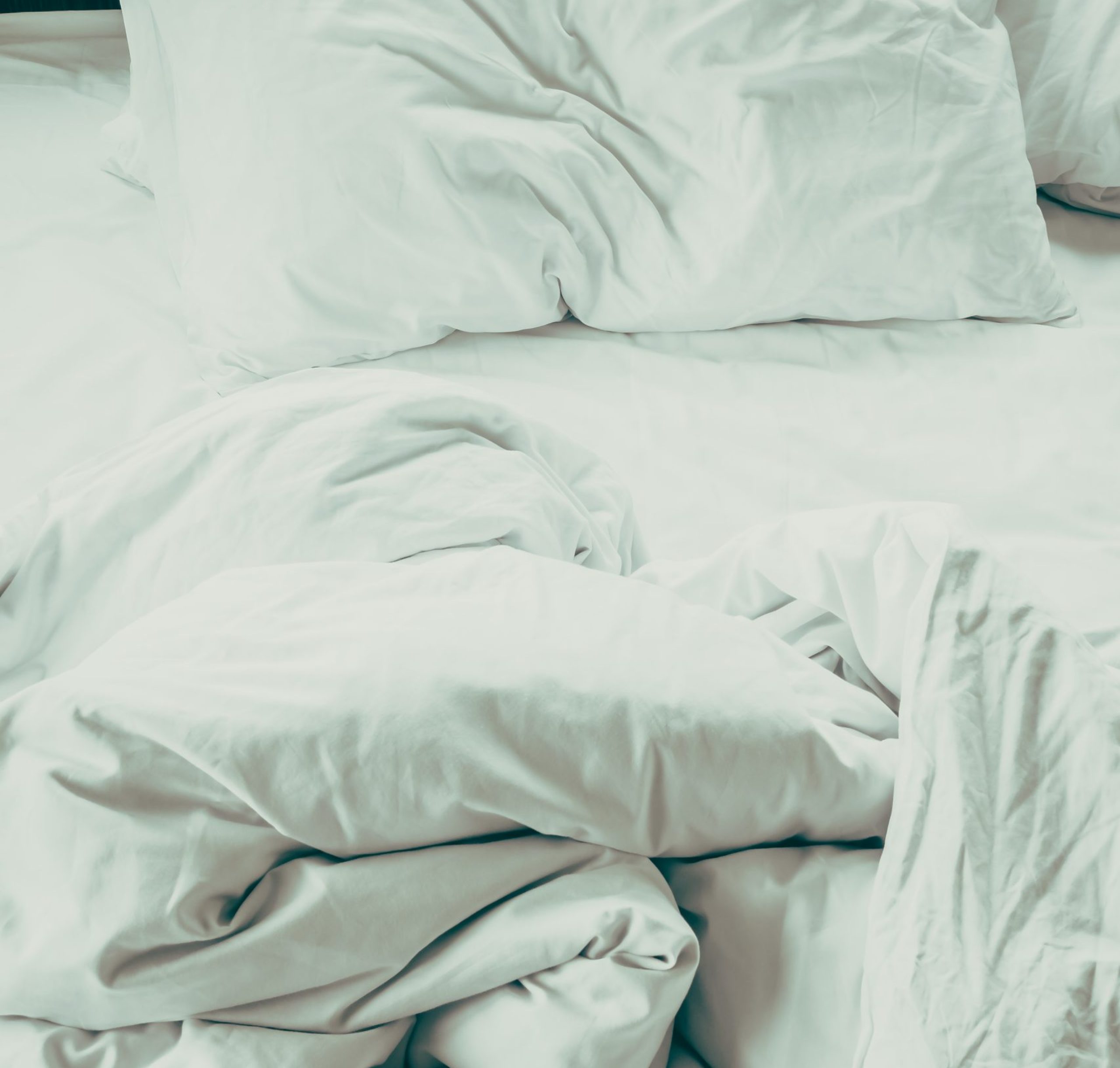 White sheet pillow on messy bed decoration in bedroom interior - Vintage Filter